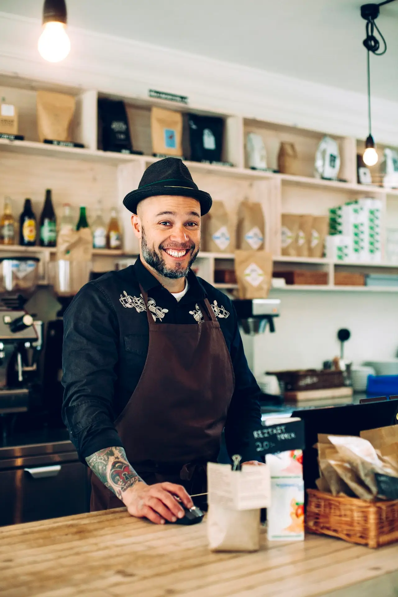 Portrait of smiling male barista at counter in coffee shop
